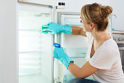 Woman cleaning fridge - Cleaning tips for moving