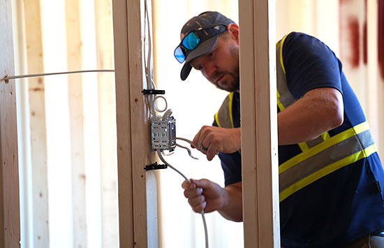 BigSteelBox staff installing electrical into a modified shipping container