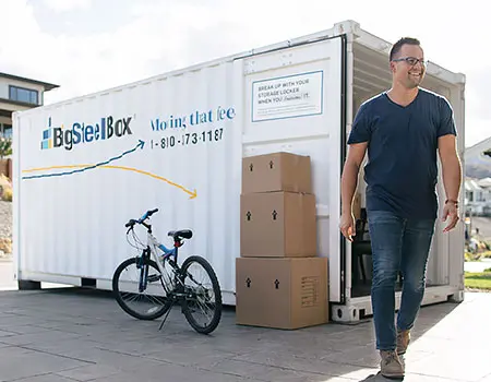 Man loading a moving container in driveway - BigSteelBox