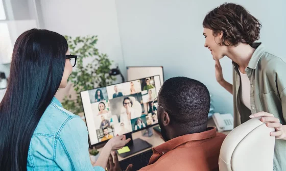 Employees meeting in office and over video conference