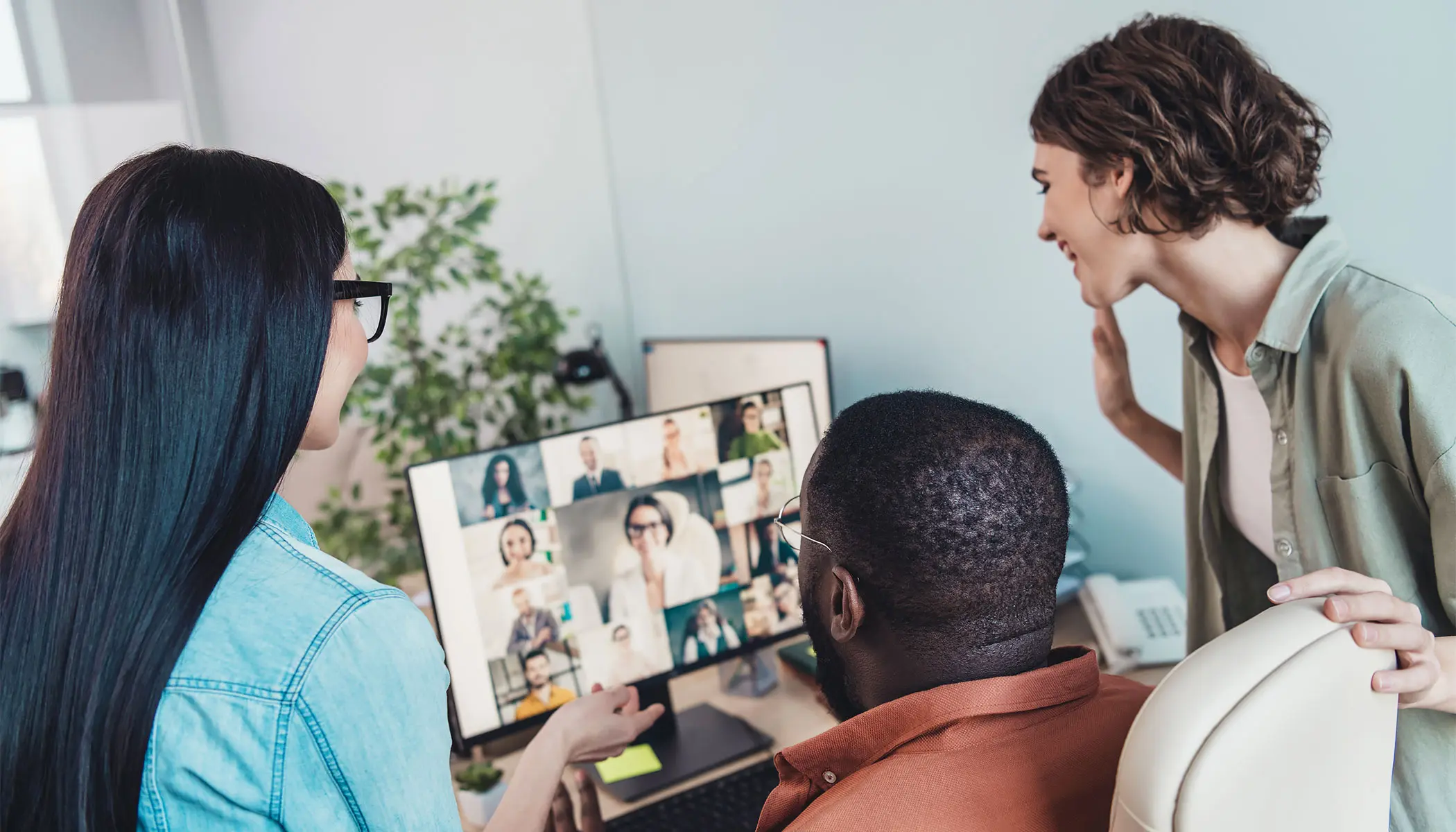 Employees meeting in office and over video conference