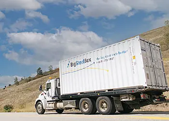 https://www.bigsteelbox.com/content/uploads/2023/06/truck-moving-shipping-container-350.webp