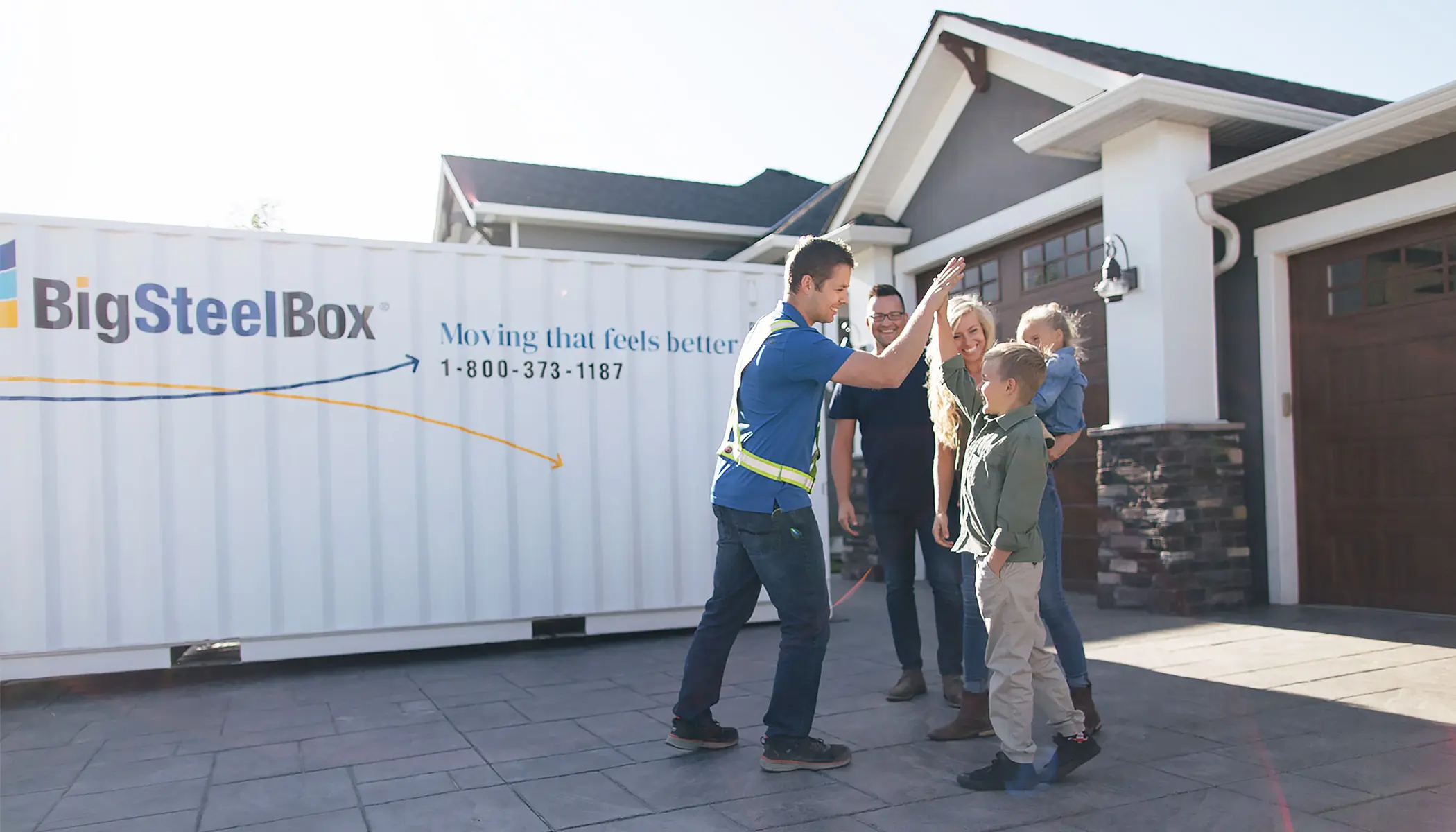 Family with a BigSteelBox moving and storage container in their driveway