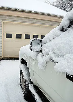 Car parked outside garage during winter
