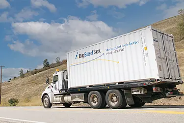 BigSteelBox truck delivering a 20' shipping container