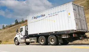 BigSteelBox truck transporting a 20' portable storage container rental